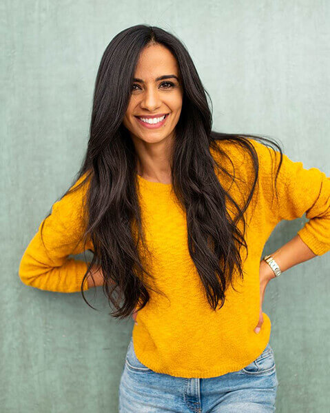 Smiling woman with long brown hair and yellow top