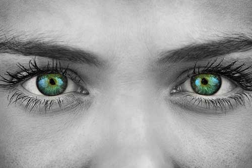 Black and white photo of a woman with green colorized eyes