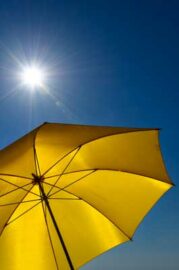 Yellow umbrella against sunny blue sky