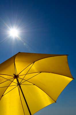 Yellow umbrella against sunny blue sky