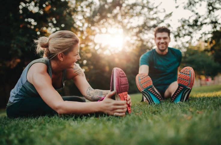 Couple stretching in park