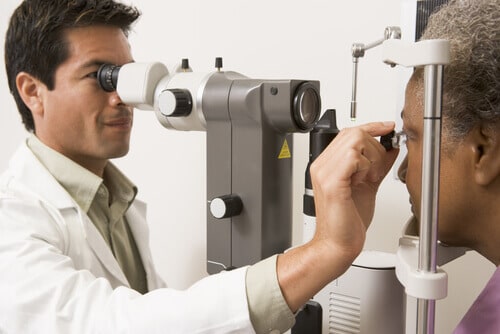 Eye doctor examining older male patient