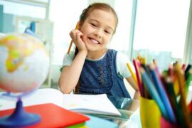 Smiling young girl at school desk
