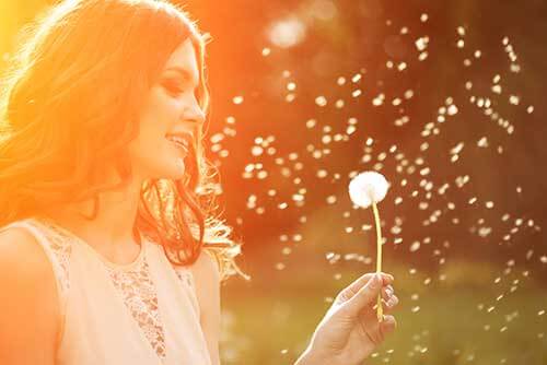 Woman outside with dandelion