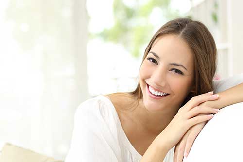 Smiling woman leaning against back of couch
