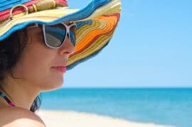 Woman with sunglasses and hat at beach