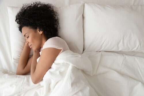 woman sleeping in bed with white linens