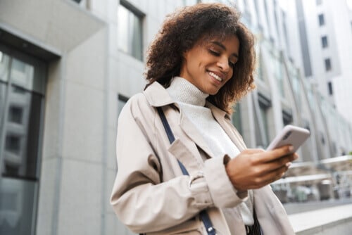 Woman in neutral colors looking at phone